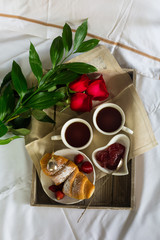 Valentines day table setting with plate, gift, red ribbon and roses. background