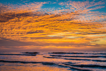 Waves in the Atlantic Ocean and sunrise, at Folly Beach, South C