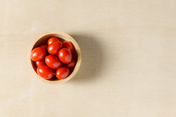 Top view fresh tomato slice and bowl on wood background.