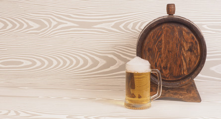 Beer mug and barrel on a wooden background