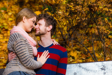 Fototapeta premium Lovers couple in autumn park on bench