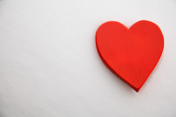 Fototapeta premium Red heart in the snow on a winter background.