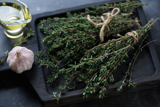 Close-up of fresh thyme bunches on a wooden chopping board