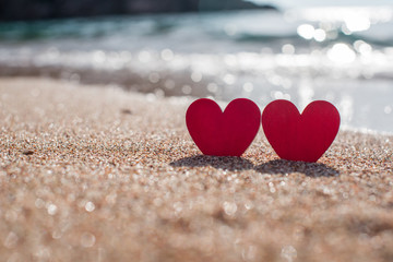 Fototapeta premium romantic symbol of two hearts on the beach 