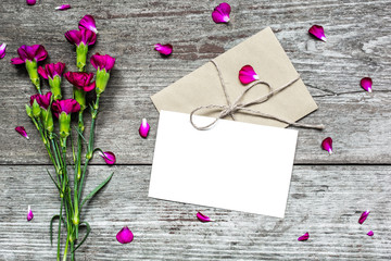 blank white greeting card and envelope with purple carnation flowers
