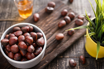chestnuts with roasted coffee beans on wooden background. 