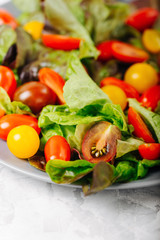 Healthy salad of red and yellow cherry tomato and herbs  close up