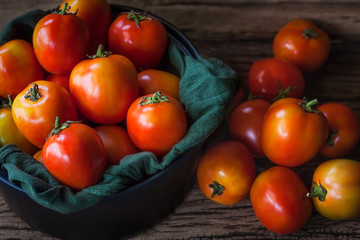 Fototapeta na wymiar tomatoes on wood background. Selective focus .