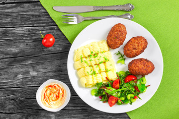 mashed potatoes sprinkled with greens,  juicy meat cutlets