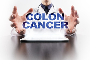 Medical doctor using tablet PC with colon cancer medical concept.