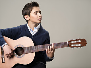 Obraz premium Caucasian boy playing on acoustic guitar.