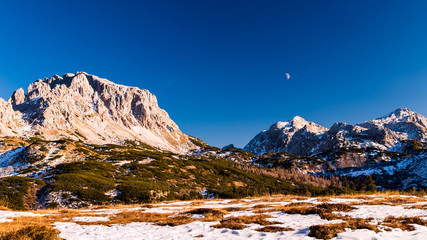 Obraz na płótnie Canvas moon is rising behind the mountains