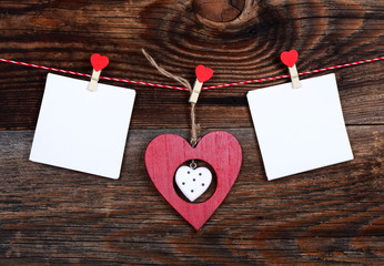 Two hearts and a blank sheet of paper on a beautiful old wooden background as love concept for valentines day
