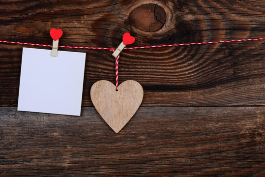 Heart and a blank sheet of paper on a beautiful old wooden background as love concept for valentines day