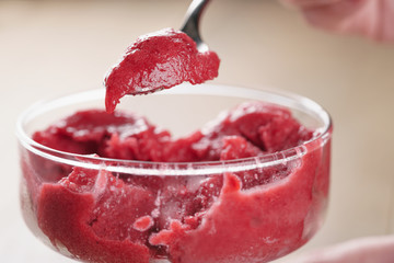 eating raspberry sorbet ice cream with spoon closeup, shallow focus - obrazy, fototapety, plakaty