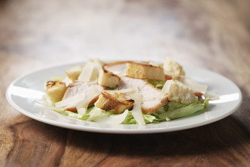 fresh simple caesar salad with chicken, shallow depth of field