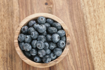 fresh blueberries in wood bowl on table, shallow focus