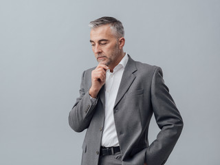 Businessman thinking with hand on chin