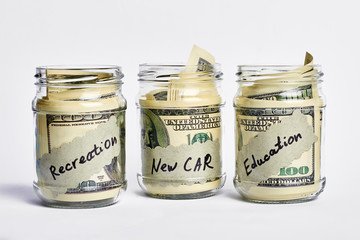 Dollars in money jars. Savings for education and recreation.
