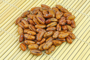 Brown pinto beans on bamboo mat