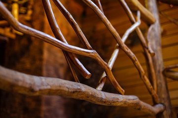 yellow wooden bridge with railings made of branches of trees © Angelov