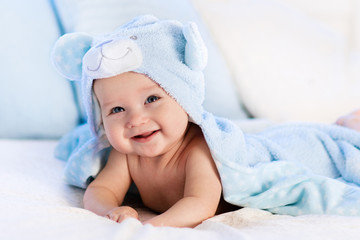 Fototapeta na wymiar Baby in towel after bath in bed
