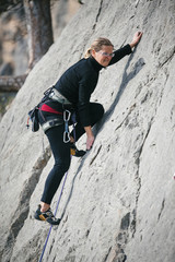 woman climbs a rock