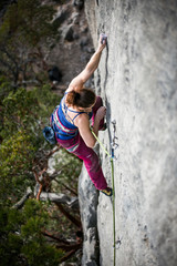 woman climbs a rock