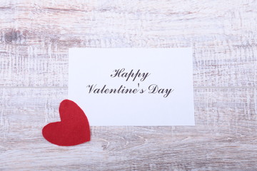Valentine card with red heart on wooden desk