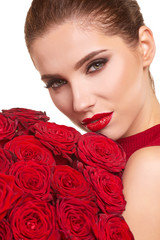 Beautiful model posing with red roses in the studio. Valentines