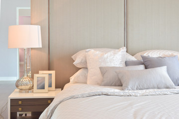 Classic bedroom interior with pillows and reading lamp on bedside table