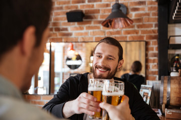 View from back of man clinking glasses with friend