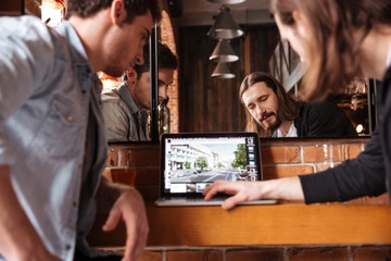 Cropped image of friends looking at laptop