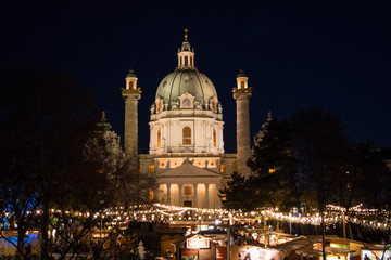 Fototapeta na wymiar Christmas Markets below Karlskirche illuminated at night in Vienna