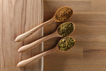 Various spices spoons on wooden table. Top view with copy space