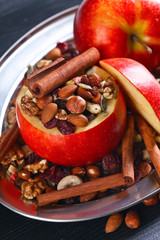 Red juicy apple with assorted nuts , raisins and cinnamon