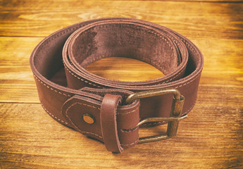 One man's leather belt on wooden table