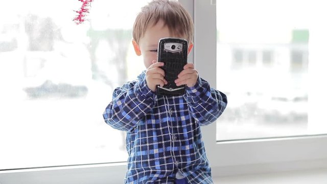Child boy photographed with a smartphone.