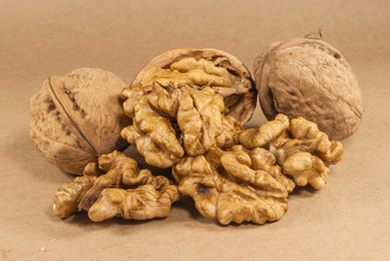 Walnut kernels and whole walnuts on kraft paper, close up, horiz