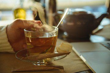 Close up of a man drinking coffee at a cafe. Indoors.