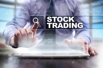 Fototapeta na wymiar Businessman using tablet pc and selecting stock trading.