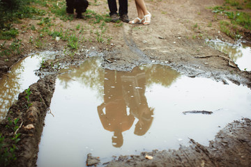 people reflected in a puddle