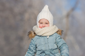 Portrait of little girl in warm wear walks in winter