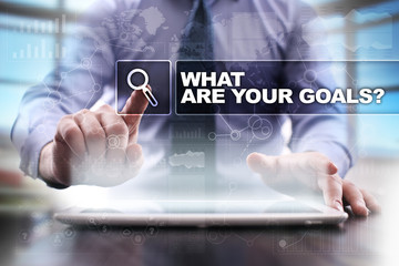 Businessman using tablet pc and selecting what are your goals.