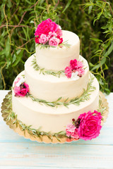 Fototapeta na wymiar Beautiful wedding cake with flowers, outdoors. Three levels