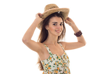 young cheerful woman in straw hat and sarafan with floral pattern smiling on camera isolated on white background