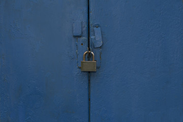 Closeup shot of metal blue door with a lock