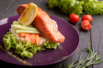 Salmon and rice with cherry tomato on purple plate