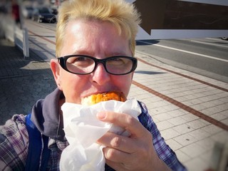 Junge Frau beim Fischbrötchen essen