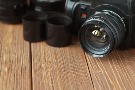 retro camera, lenses and film on the wooden table, retro concept, selected focus